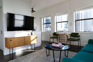 Reside Seattle Downtown, a Wyndham Residence في سياتل: غرفة معيشة مع تلفزيون بشاشة مسطحة على جدار