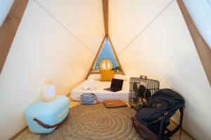 a room with a tent with a bed and a suitcase at Kampaoh Hostel El Palmar in El Palmar