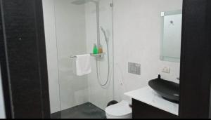 ein Bad mit einer Glasdusche und einem schwarzen Waschbecken in der Unterkunft Urbanizacion privada "El Sol", Villa K2 in Machala
