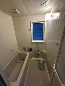 łazienka z wanną, prysznicem i oknem w obiekcie AYA-Naruto w mieście Naruto