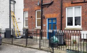 a fence with a fire hydrant in front of a building at Hyde Brewery House - 2 bedroom house with parking in Winchester