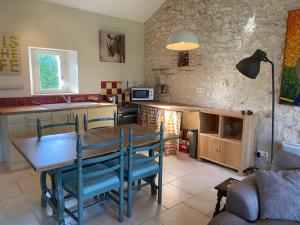 cocina con mesa de madera y sillas azules en Les Granges Lestang, en Sainte-Innocence