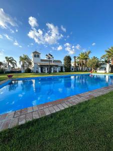 ein großer blauer Pool vor einem Haus in der Unterkunft Cortijo Pavia in Écija