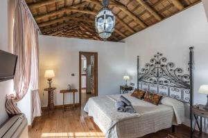 ein Schlafzimmer mit einem großen Bett mit Holzboden in der Unterkunft Cortijo Pavia in Écija + 30 Fotos
