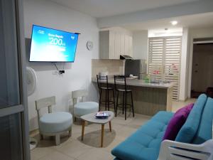 ein Wohnzimmer mit einem blauen Sofa und einem TV in der Unterkunft Aqualina green in Girardot
