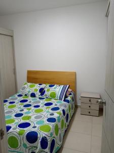 ein Bett mit einer Blumendecke in einem Schlafzimmer in der Unterkunft Aqualina green in Girardot