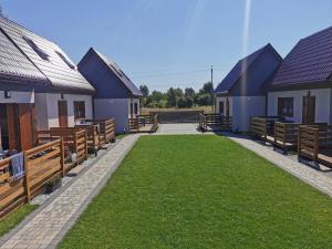 une rangée de maisons avec bancs et pelouse dans l'établissement NADMORSKI RESORT, à Niechorze