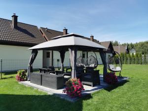 a gazebo with chairs and flowers in a yard at NADMORSKI RESORT in Niechorze