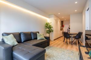 a living room with a couch and a table at Trindade Bliss: 1BR w/ Free Parking by LovelyStay in Porto