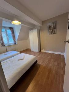 a bedroom with a large white bed and a window at Duplex 6 Personnes Hyper Centre in Dieppe