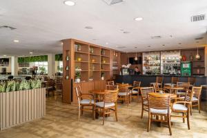 a restaurant with tables and chairs and a bar at Suítes Inside Windham Sao Paulo Paulista in Sao Paulo