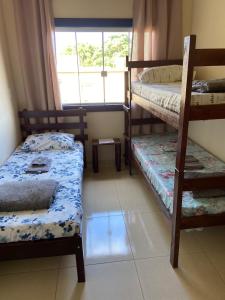 a bedroom with two bunk beds and a window at Pousada Casarão in Cruzília