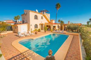 a villa with a swimming pool in front of a house at Villa Ebro - PlusHolidays in Ifach