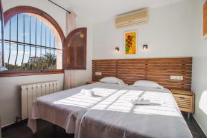 a bedroom with a large bed with two white towels at Villa Ebro - PlusHolidays in Ifach +22 photos
