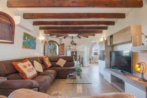 a living room with a couch and a tv at Villa Ebro - PlusHolidays in Ifach