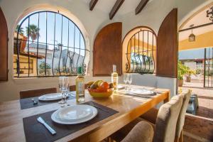 a dining room with a table and chairs and windows at Villa Ebro - PlusHolidays in Ifach