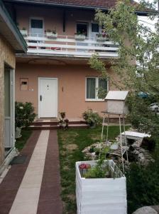 ein Haus mit einem Balkon und einem Hof mit Pflanzen in der Unterkunft Apartmani Pavlov in Aranđelovac
