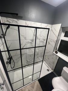 a bathroom with a shower with a glass wall at Cosy home perfect for families and contractors in Darlington