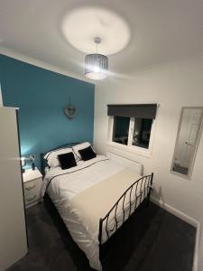 a bedroom with a bed with a blue wall at Cosy home perfect for families and contractors in Darlington