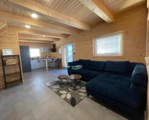 a living room with a blue couch and a kitchen at Rezortík Gerlachov CHATA 1 in Svätý Jur