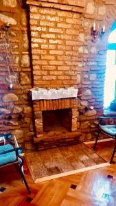 a stone fireplace in a room with two chairs at Dabakhnebi in Telavi