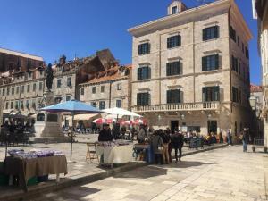a street with tables and umbrellas in front of a building at Tailor Apartment with a Private Terrace in Dubrovnik