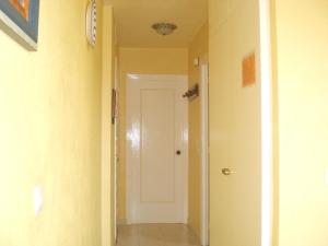 a hallway with a white door and yellow walls at Minerva Jupiter Apartments in Benalmádena