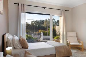 a bedroom with a bed and a large window at Villa Colina in Salir de Matos +19 photos