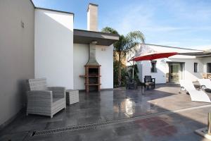 a patio with white furniture and a red umbrella at Villa Colina in Salir de Matos