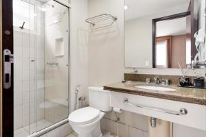 uma casa de banho com um WC, um chuveiro e um lavatório. em Suítes Inside Hotel Windham Paulista em São Paulo