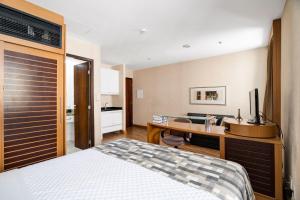 a bedroom with a bed and a desk with a sink at Suítes Inside Hotel Windham Paulista in Sao Paulo