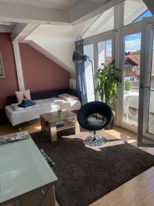 a living room with a black chair and a couch at Kays Home in Bad Wörishofen