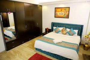 - une chambre avec un grand lit et un miroir dans l'établissement Fortune Home Service Apartment 3Bhk,J-215 Saket, à New Delhi