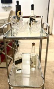 a glass table with wine bottles and glasses on it at Fortune Home Service Apartment 3Bhk,J-215 Saket in New Delhi