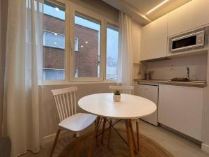 eine Küche mit einem Tisch, 2 Stühlen und einem Fenster in der Unterkunft Cozy studio in Tetuan - En 1/7 in Madrid