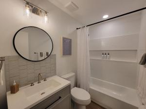 Un baño con lavabo, inodoro y espejo. en Elegant Cozy Spot to unwind! UCF/MCO/Parks/Beach, en Orlando