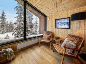 Habitación con ventana, 2 sillas y mesa. en Ski-in-out hytte på Kvitfjell, en Strande