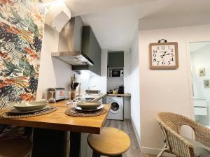 une cuisine avec une table et une horloge au mur dans l'établissement Le Floral - Parking - Self check in, à Chartres 4 autres photos