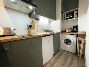 a kitchen with green cabinets and a washing machine at Le Floral - Parking - Self check in in Chartres