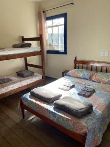 a bedroom with two bunk beds and a window at Pousada Casarão in Cruzília
