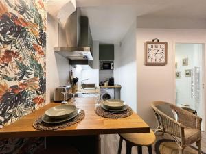 une cuisine avec une table en bois et des plaques de cuisson. dans l'établissement Le Floral - Parking - Self check in, à Chartres