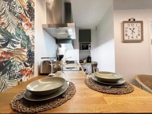 une cuisine avec deux assiettes sur une table en bois dans l'établissement Le Floral - Parking - Self check in, à Chartres