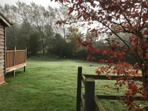 un parque con un banco de madera en un campo en The Nut House - Squirrel Lane Lodges Ludlow, en Ludlow