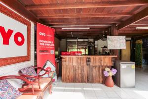 a restaurant with a v sign and a bench and a counter at OYO 909 Guiding Star Resort in Hang Dong