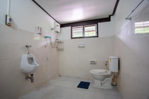 a bathroom with a toilet and a urinal and a sink at OYO 909 Guiding Star Resort in Hang Dong