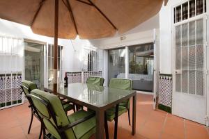 a dining room with a table and chairs and an umbrella at Apartament Don Juan Manuel in Torremolinos