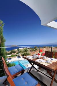 a table and chairs on a balcony with a view of a pool at Elounda Living Residences in Elounda