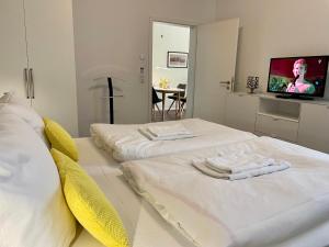ティースゾーにあるHaus Sterntaucher Ferienwohnung "Sonnenstern"のテレビ付きの客室で、白いベッド2台が備わります。