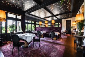 a dining room with tables and chairs and windows at Château de Maubreuil in Carquefou