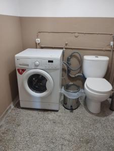 ein Badezimmer mit einer Waschmaschine und einem WC in der Unterkunft Ionias Penthouse in Korinthos